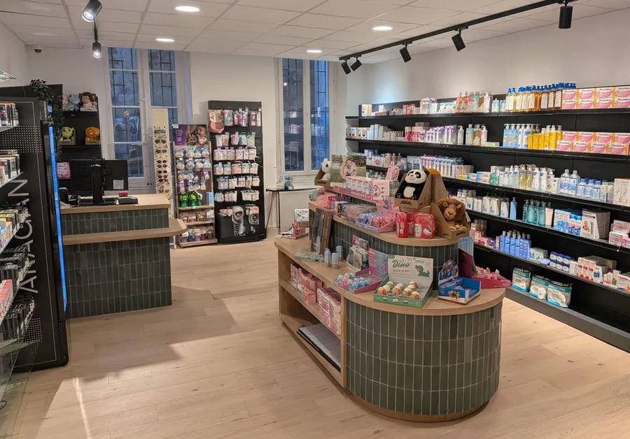 L'espace bébé : soins, hygiène et jouets autour d'un présentoir carrelé de vert